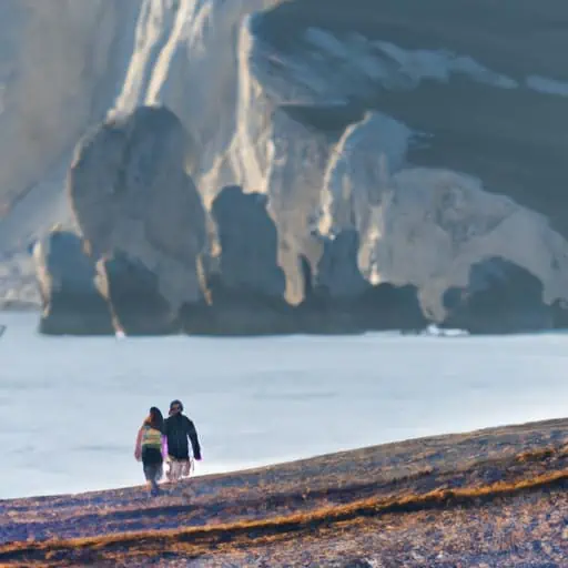זוג שנהנה מטיול רומנטי על החוף, כשברקע סלע אפרודיטה האייקוני.