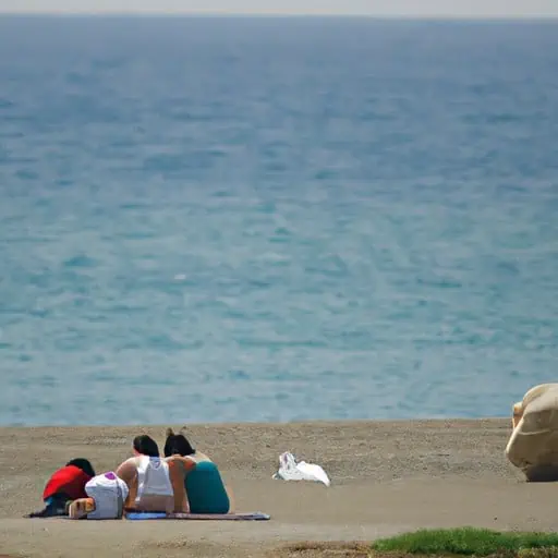 משפחה מרגיעה על החולות הרכים של חוף מבודד בקפריסין.