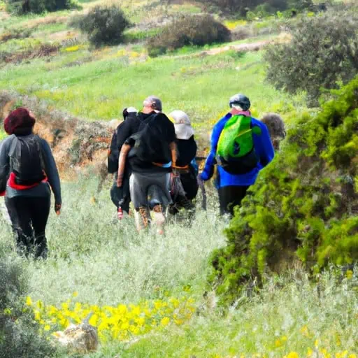 קבוצת מטיילים החוקרים את האזור הכפרי הקפריסאי, עם צמחייה עבותה וגבעות מתגלגלות